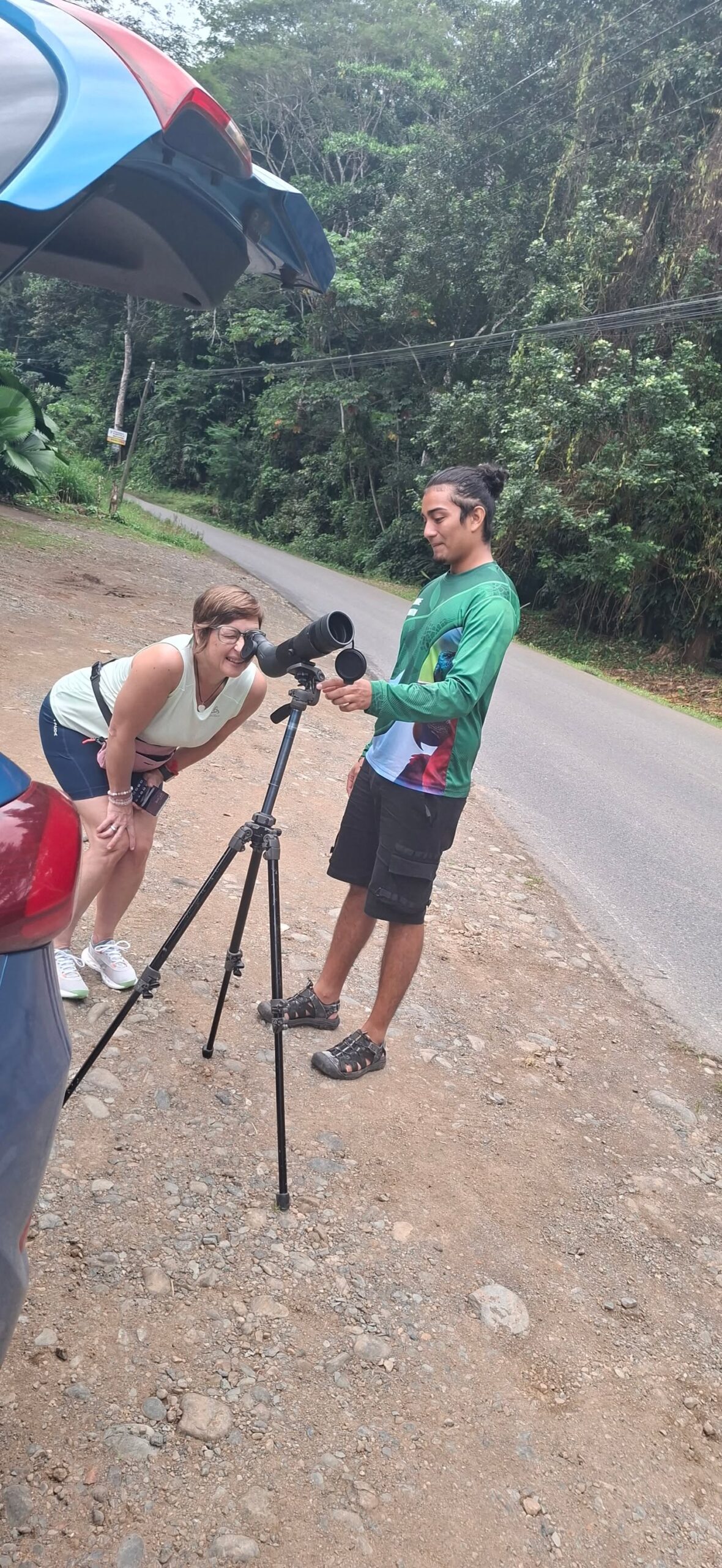 Local birdwatching guide helping a guest use a spotting scope in Costa Rica